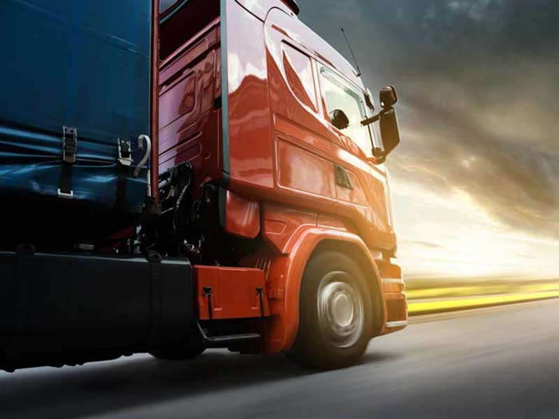 large truck driving on sunset road