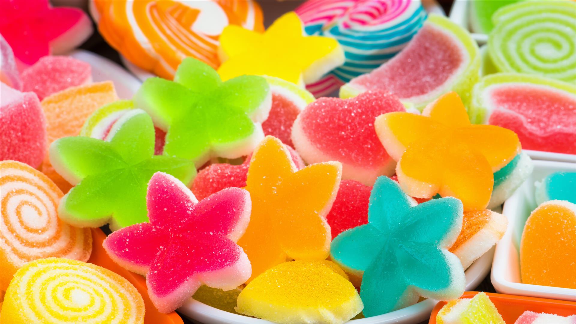Colourful sugary candy, Assort various sweet candies orange juice on wooden board with apples