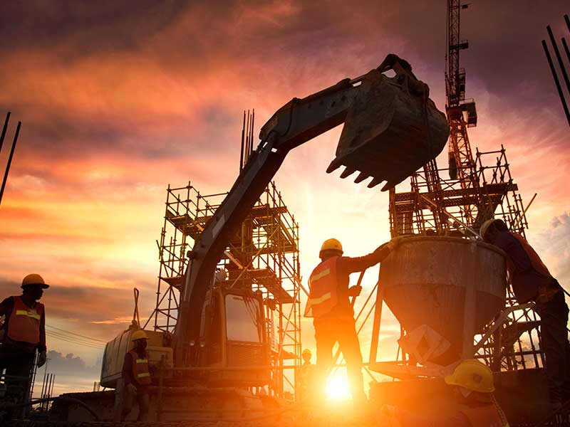 construction workers with equipment in sunset