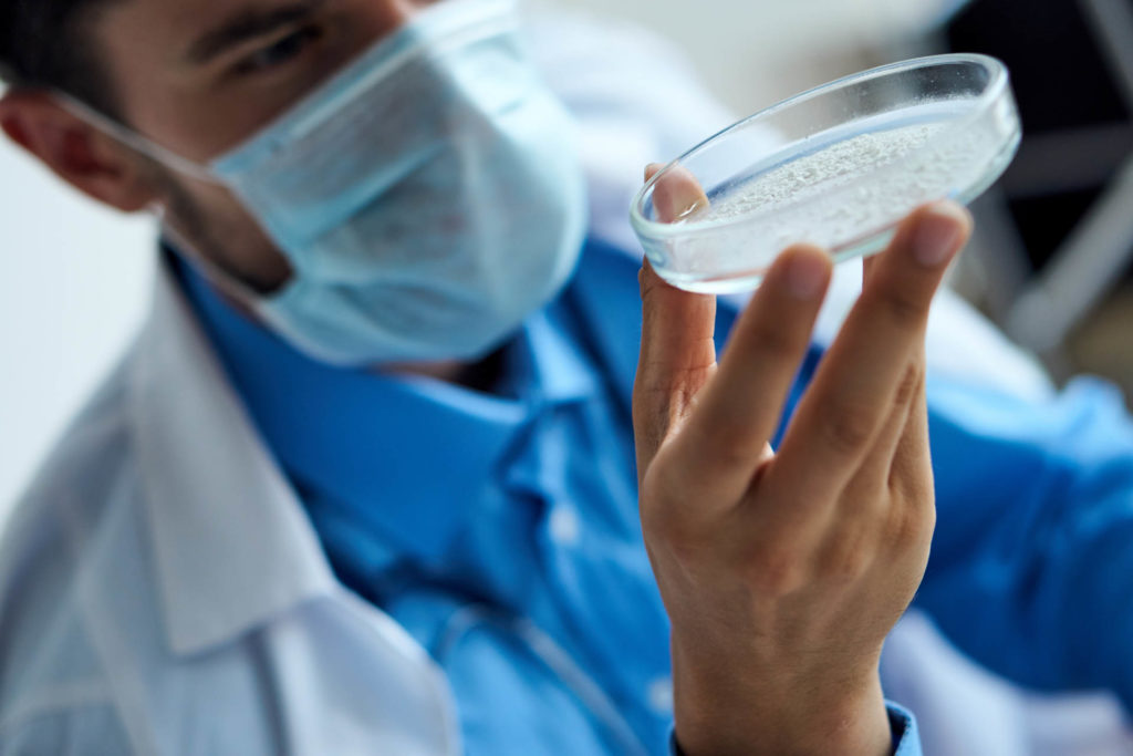 laboratory technician inspecting a sample of silicon dioxide