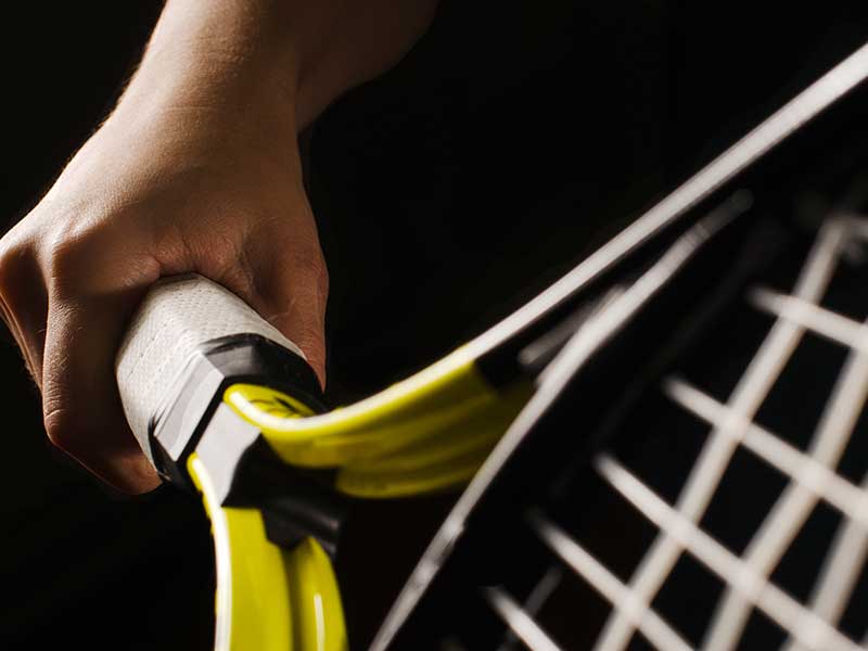 hand holding tennis rack